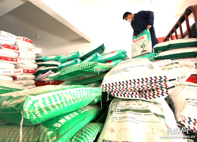 邯郸市永年区西河庄乡北河庄村一农资销售网点工作人员正在搬运化肥.
